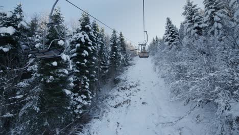 POV-Fahrt-Mit-Dem-Skilift-Im-Skigebiet-Im-Winterblauen-Himmelshintergrund