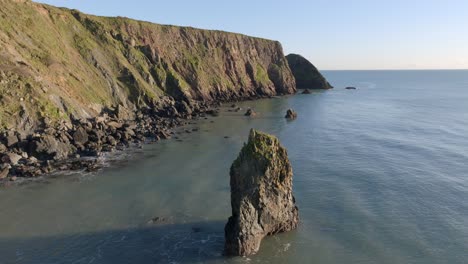 Cinematic-drone-sea-stack-with-calm-seas-at-full-tide-Copper-Coast-Waterford-Ireland