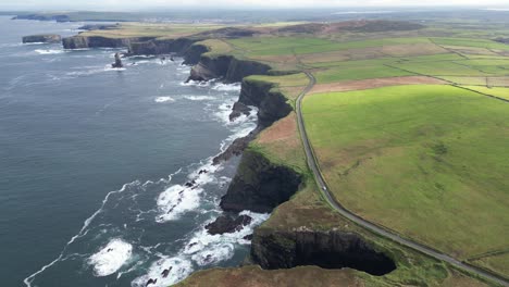 Wide-aerial-drone-shot-above-the-coastal-farm-fields-of-the-Kilkee-Cliffs-Ireland-countryside