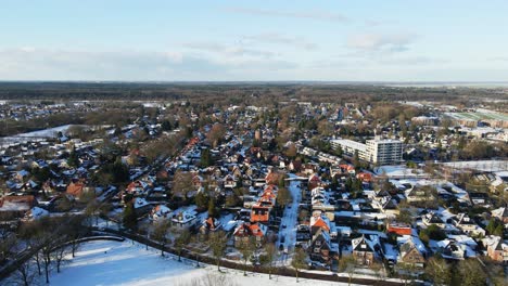 Aerial-of-a-wealthy-suburban-neighborhood-covered-in-snow-on-a-sunny-winter-day