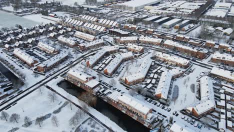 Beautiful-aerial-of-a-small-town-suburban-neighborhood-covered-in-snow-on-a-sunny-day
