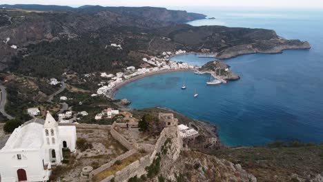 Travelling-Aerial-Shot-Moving-Away-from-Kapsali-Bay-Revealing-Chora-Castle-Church,-Greece
