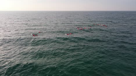 Swimmers-in-the-sea-near-Castelldefels-Beach,-Barcelona,-with-safety-buoys,-aerial-view