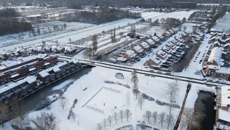 Beautiful-aerial-of-a-rustic-suburban-neighborhood-covered-in-snow-on-a-sunny-winter-day