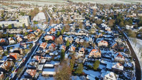 Aerial-overview-of-a-beautiful-wealthy-neighborhood-covered-in-snow-on-a-sunny-winter-day