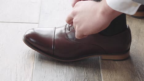 Man-Tying-Brown-Leather-Dress-Shoe