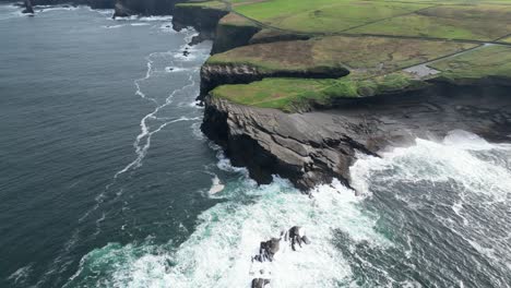 Aerial-drone-shot-of-the-coastal-Kilkee-Cliffs-in-the-countryside-fields-of-Ireland-in-County-Clare-along-the-Wild-Atlantic-Way