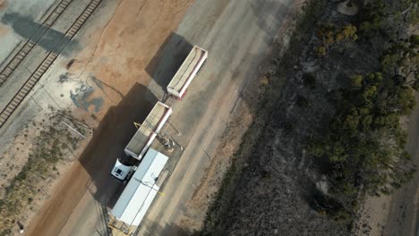 Luftaufnahme-Von-Oben-Nach-Unten-Eines-Lastkraftwagens-Während-Der-Verteilung-Des-Geernteten-Getreides-In-Westaustralien