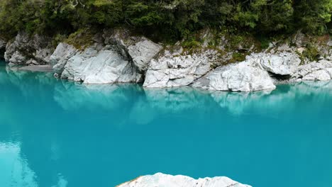 Rocks-mirrored-in-the-clear-waters-of-Hokitika-Gorge,-a-mesmerizing-display-of-nature's-reflection