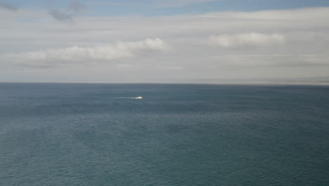 4K-Kino-Drohnenaufnahme-Eines-Einsamen-Fischerbootes,-Das-Die-Bucht-Von-Monterey-In-Kalifornien-überquert,-Mit-Einer-Einzelnen-Möwe,-Die-Sich-Durch-Das-Bild-Bewegt