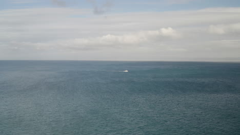 4K-cinematic-locked-off-drone-shot-of-lone-fishing-boat-crossing-Monterey-Bay-in-California