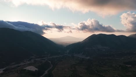 Vista-Aérea-Panorámica-Del-Sombreado-Valle-Montañoso-Albanés-Durante-La-Puesta-De-Sol-Nublada