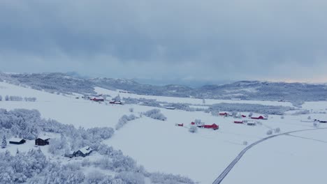 Escena-Invernal-Con-Cabañas-Rodeadas-De-árboles-Forestales-Cubiertos-De-Nieve-En-Indre-Fosen,-Noruega-Durante-El-Invierno---Toma-Aérea