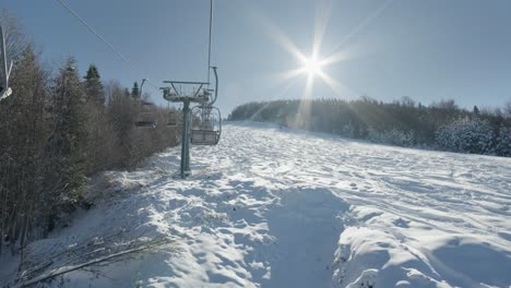 POV-Fahren-Auf-Skiliften-Im-Skigebiet,-Leere-Pisten,-Sonniger-Tag,-Sunstar