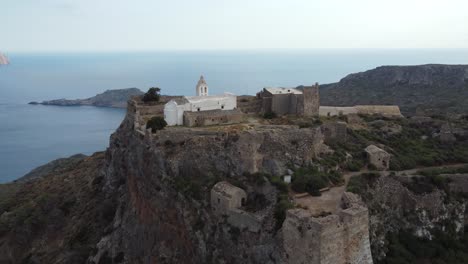 Aerial-Orbital-Cinematic-View-over-Castle-of-Chora-Kythira-Revealing-Kapsáli-Bay,-Greece