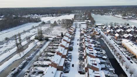 Beautiful-aerial-of-a-snow-covered-street-with-homes-on-a-picturesque-winter-day