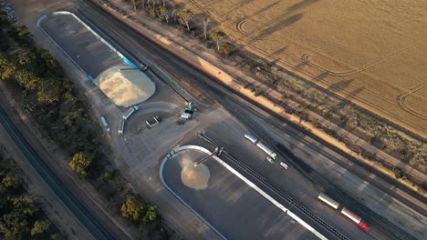 Aerial-birds-eye-shot-of-truck-arriving-industrial-distribution-place-to-unload-grain-in-grid