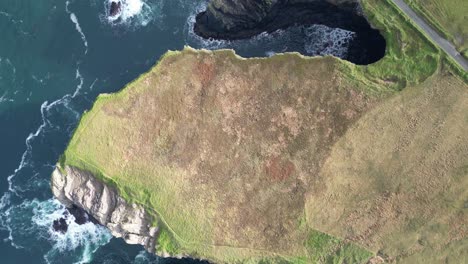 Aerial-drone-shot-of-the-coastal-Kilkee-Cliffs-of-Ireland,-panning-over-the-countryside-Irish-landscape