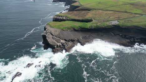 Luftdrohnenaufnahme-Der-Wellen,-Die-Auf-Den-Kilkee-Klippen-Entlang-Des-Wild-Atlantic-Way-In-Der-Grafschaft-Clare-In-Irland-Krachen