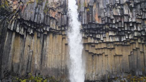 Close-up-slowmotion-shot-of-water-falling-down-over-the-Svartifoss-waterfall-in-autumn-colors