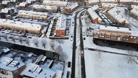 Car-driving-over-clean-roads-in-a-snow-covered-town