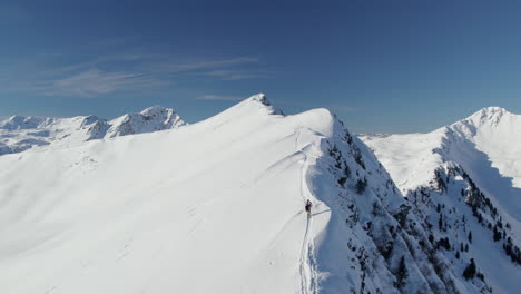 Persona-Caminando-Sobre-La-Cresta-Nevada-De-La-Montaña-Reiterkogel-En-Invierno-En-Hinterglemm,-Austria