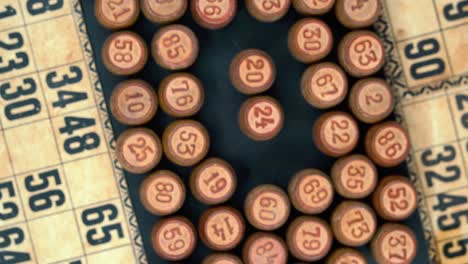 Cinematic-close-up-rotating-smooth-zoom-out-shot-from-above-of-a-pile-of-Bingo-wooden-barrels-in-a-square,-woody-figures,-old-numbers-background,-vintage-board-game,-professional-lighting,-4K-video