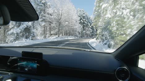 POV-passenger-seat-driving-expensive-sport-car-through-snow-covered-mountain-roads-winter-sunny-day