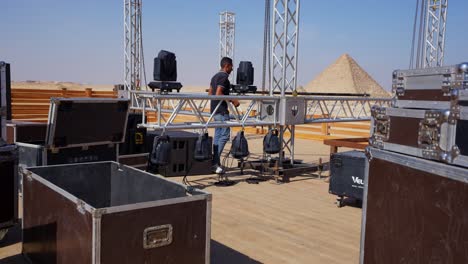 people-prepare-the-stage-for-a-party-in-the-desert-beside-the-Pyramids,-Giza-in-Egypt,-Establishment-shot,-static-shot