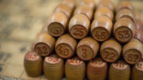 Cinematic-creative-close-up-smooth-backwards-macro-shot-of-Bingo-wooden-barrels-in-a-row,-woody-figures,-old-numbers-background,-vintage-board-game,-slow-motion-120-fps-commercial-gimbal-video