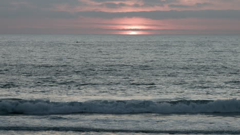 The-sun-dips-below-the-horizon-during-sunset-at-a-beach-in-Cardiff,-California