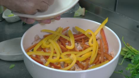 Up-close-shot-of-chef-hands-putting-different-bell-peppers-in-bowl