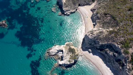 Aerial-View-over-Kaladi-Beach-with-Crystal-Clear-Waters-and-Sun-Reflection-in-Kythira-Island,-Greece
