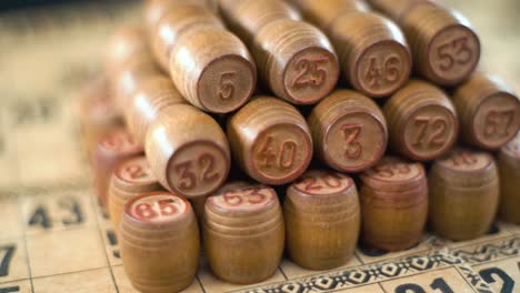 Cinematic-creative-smooth-dreamy-macro-shot-of-Bingo-wooden-barrels-in-a-row,-woody-figures,-old-numbers-background,-vintage-board-game,-slow-motion-120-fps-commercial-gimbal-video,-crane-movement