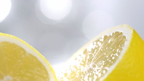 Zitronenscheiben-Rotieren-In-Zeitlupe-Vor-Verschwommenem-Weißem-Hintergrund,-Makroaufnahme
