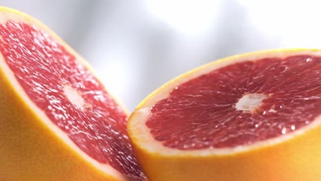 Makroaufnahme-Von-Geschnittenen-Grapefruits,-Die-Sich-In-Zeitlupe-Drehen,-Früchte-In-Lebendigen-Farben