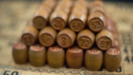 Cinematic-creative-close-up-smooth-forward-macro-shot-of-Bingo-wooden-barrels-in-a-row,-woody-figures,-old-numbers-background,-vintage-board-game,-slow-motion-120-fps-commercial-gimbal-video