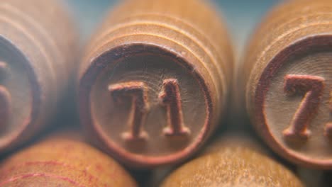 Cinematic-macro-smooth-shot-of-Bingo-wooden-barrels-in-a-row,-woody-figures,-old-numbers-vintage-board-game,-number-75,-slow-motion,-commercial-gimbal-movement,-pan-right