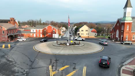 Aerial-flyover-of-traffic-circle-with-American-flag