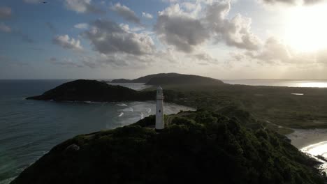 Aerial-view-of-the-sunset-on-Conchas-lighthouse-and-beaches-of-Ilha-do-Mel,-Paran?