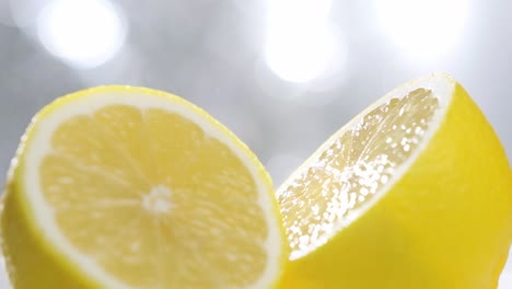 Water-spray-particles-falling-on-fresh-Half-cut-lemon,-Slow-motion-shot