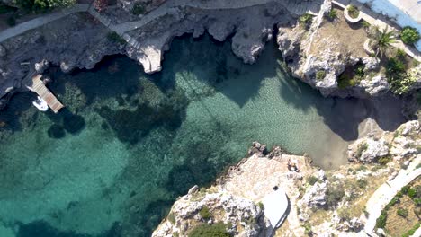 Aerial-Top-View-Avlemonas-Bay-Swiming-Area-with-Crystal-Clear-Waters-and-Couple,-Kythira-Island,-Greece