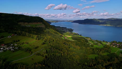 Aerial-drone-shot-over-mountain-range-covered-with-green-vegetation-on-both-sides-of-a-fjord-in-Norway-on-a-cloudy-day