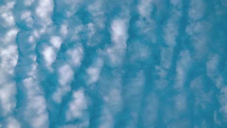 Ein-Filmischer-Zeitraffer-Von-Unten,-Surfende-Weiße-Wolken,-Blauer-Himmel,-Tageslichtsonne,-Statisches-4K-Video
