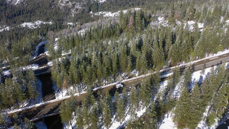 Drone-tilting-over-the-snowy-Interstate-80-in-the-highlands-of-wintry-California,-USA