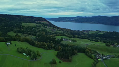 Aerial-drone-shot-flying-high-over-typical-secluded-houses-beside-fjord-in-Norway-on-a-cloudy-day