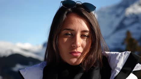 Caucasian-brunette-smile,-sunny-winter-day-with-blurry-Switzerland-mountains