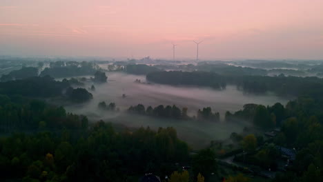 Eine-Drohne-Fliegt-über-Die-Wolken-Mit-Baumwipfeln-Und-Dem-Rosa-Sonnenuntergangshimmel-Auf-Einer-Vorstadtautobahn-In-Österreich