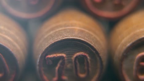 Cinematic-macro-smooth-shot-of-Bingo-wooden-barrels-in-a-row,-woody-figures,-old-numbers-vintage-board-game,-lucky-number-70,-slow-motion,-4K-commercial-gimbal-movement,-dreamy-lighting,-tilt-up