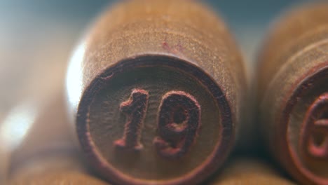 Cinematic-macro-smooth-shot-of-Bingo-wooden-barrels-in-a-row,-woody-figures,-old-numbers-vintage-board-game,-lucky-number-19,-slow-motion,-4K-commercial-gimbal-movement,-dreamy-lighting,-tilt-up